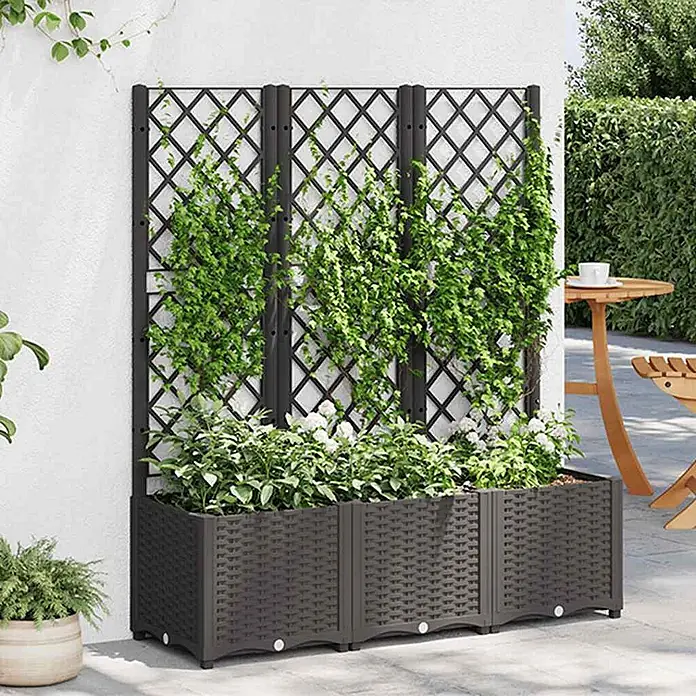 Furnicato Hochbeet - 40 x 120 x 136 cm, Kunststoff, Schwarz - Dunkelbrauner Blumenkasten im Rattan-Stil mit schwarzem Rautenrankgitter, bepflanzt mit Kletter- und Blütenpflanzen, im Freien genutzt.