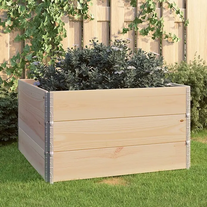 Furnicato Hochbeet - 100 x 100 x 19 cm, Holz, Braun - Hellbraunes Hochbeet aus Holz, gefüllt mit grünen Pflanzen und kleinen weißen Blüten, steht auf grünem Rasen.