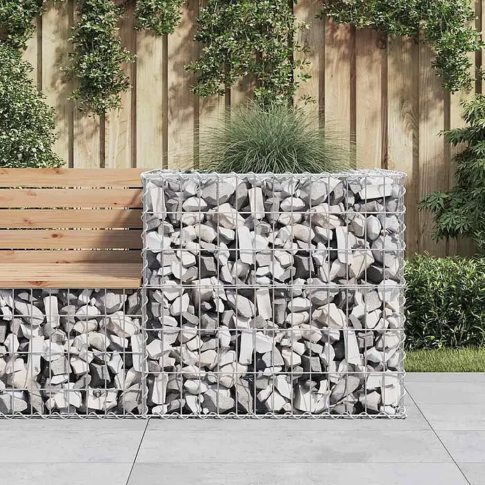 Furnicato Gabionen-Pflanzkübel verzinktes Eisen 70x70x65 cm silbern -  - Gabionenbank mit Holzsitz und passendem Gabionenpflanzgefäß, gefüllt mit hellgrauen Steinen, im Garten.