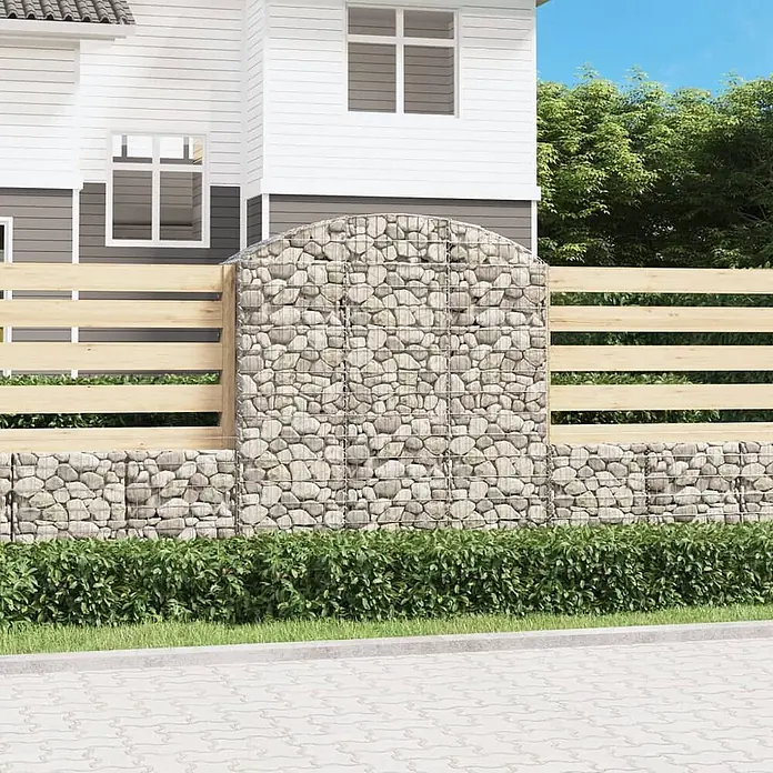 Furnicato Gabione - 180 x 150 x 50 cm, Metall, Maschenbreite: 50 mm, Maschenhöhe: 100 mm - Eine Gabionenmauer mit gewölbtem Steinelement und horizontalen hellen Holzpaneelen, in einem Garten mit Hecke.