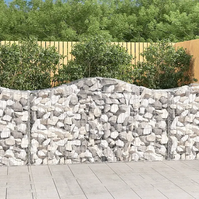 Furnicato Gabione - 50 x 200 x 120 cm, Metall, Maschenbreite: 50 mm, Maschenhöhe: 100 mm - Gabionenwand, gefüllt mit hellen Steinen, in einem Garten mit Wellenform oben und Drahtgitter.