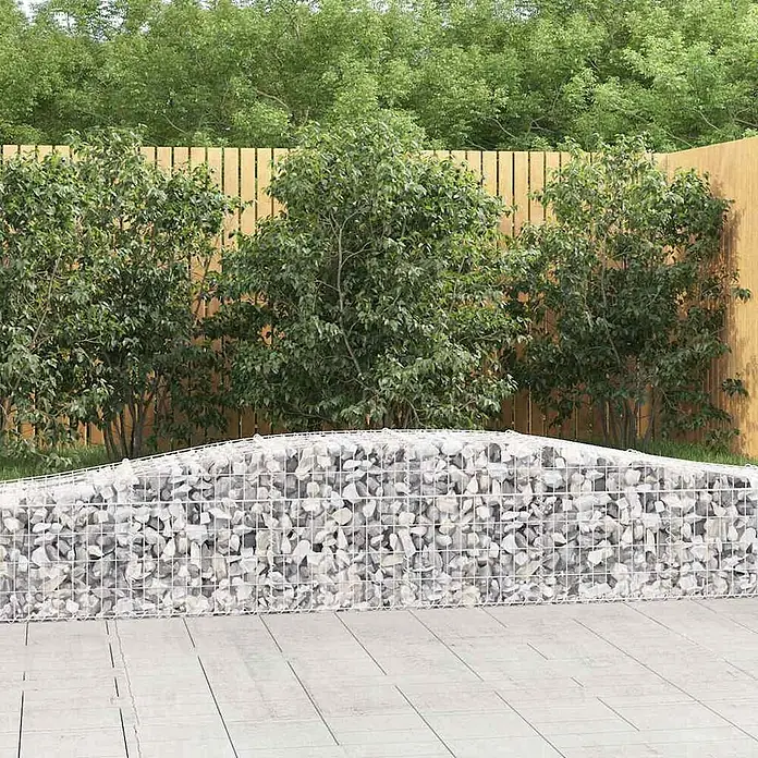 Furnicato Gabione - 50 x 400 x 60 cm, Metall, Maschenbreite: 50 mm, Maschenhöhe: 100 mm - Gabionenwand gefüllt mit hellgrauen Steinen, oben gewölbt, im Außenbereich.