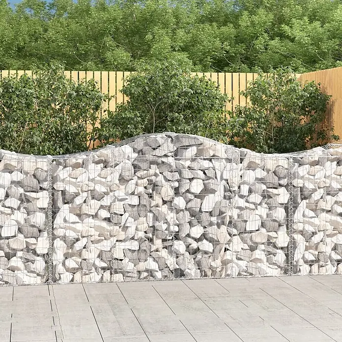 Furnicato Gabione - 50 x 200 x 120 cm, Metall, Maschenbreite: 50 mm, Maschenhöhe: 100 mm - Gabionenmauer mit hellgrauen und weißen Steinen und gewellter Oberkante in einer Gartenumgebung.