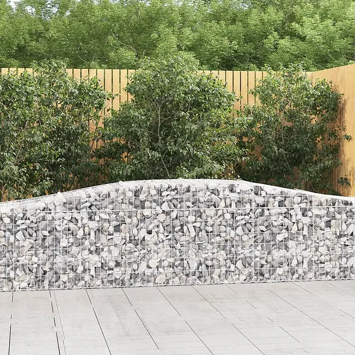Furnicato Gabione - 50 x 400 x 80 cm, Metall, Maschenbreite: 50 mm, Maschenhöhe: 100 mm - Gabionenwand gefüllt mit hellgrauen Steinen, stehend auf hellem gepflastertem Boden.