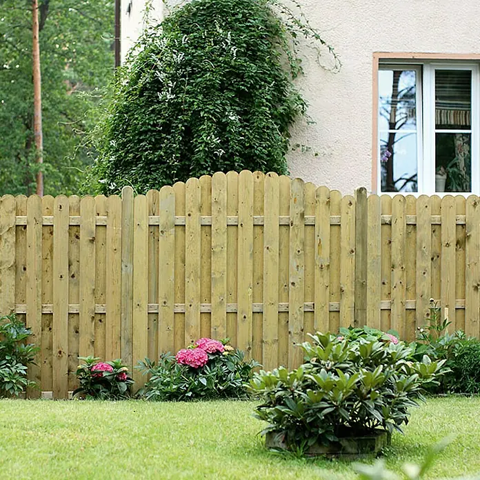 Sichtschutzelement Starnberg - 180 x 180/200 cm, Grün - Ein idyllischer Gartenzaun aus hellem Holz mit abgerundeten Latten, umgeben von üppigem Grün und blühenden Pflanzen.