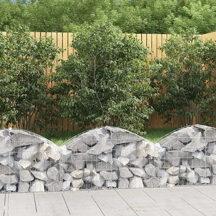 Furnicato Gabione - 30 x 100 x 60 cm, Metall, Maschenbreite: 50 mm, Maschenhöhe: 100 mm - Gabionenwand aus grauen Steinen in Drahtgeflecht, mit gewellter Oberkante, als niedriger Gartenteiler neben einer Terrasse.