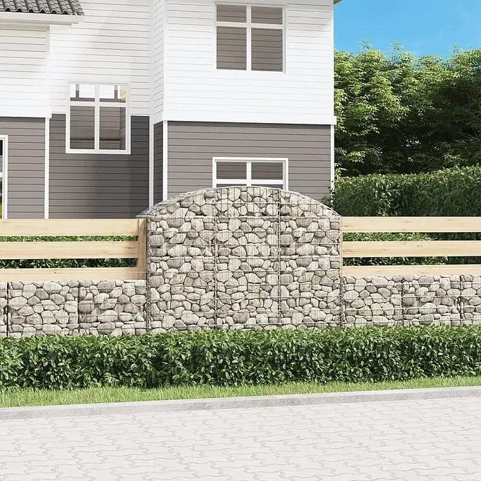 Furnicato Gabione - 140 x 150 x 50 cm, Metall, Maschenbreite: 50 mm, Maschenhöhe: 100 mm - Gabionenzaun mit hellgrauen Steinen im Drahtkorb und natürlichen Holzbohlen, als Sichtschutz vor einem Haus.
