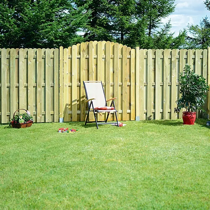 Sichtschutzelement Starnberg - 180 x 180/200 cm, Grün - Eine Holzlattenzaun umgibt einen Garten mit einem Stuhl, Blumenkorb und einer Topfpflanze.
