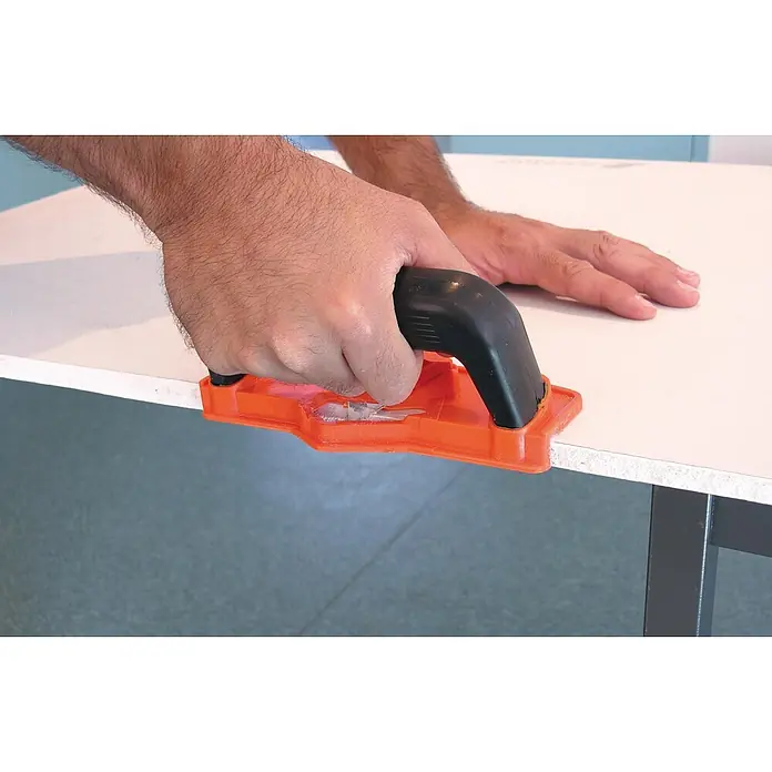 Mondelin Kantenhobel - Geeignet für: Gipskartonplatten - Mann benutzt einen orange-schwarzen Trockenbaukantenhobel zum Glätten der Gipskartonkante.