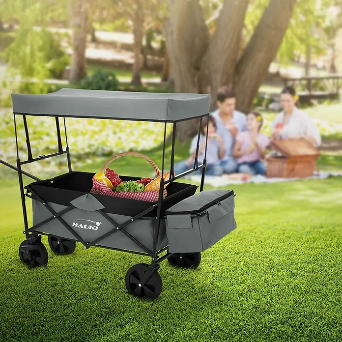 Hauki Bollerwagen Handwagen Transportwagen faltbar klappbar mit Bremse Dach und Tasche - L x B x H: 170 x 53 x 104 cm - Grauer Bollerwagen mit Dach und Kühltasche, gefüllt mit Picknickartikeln.