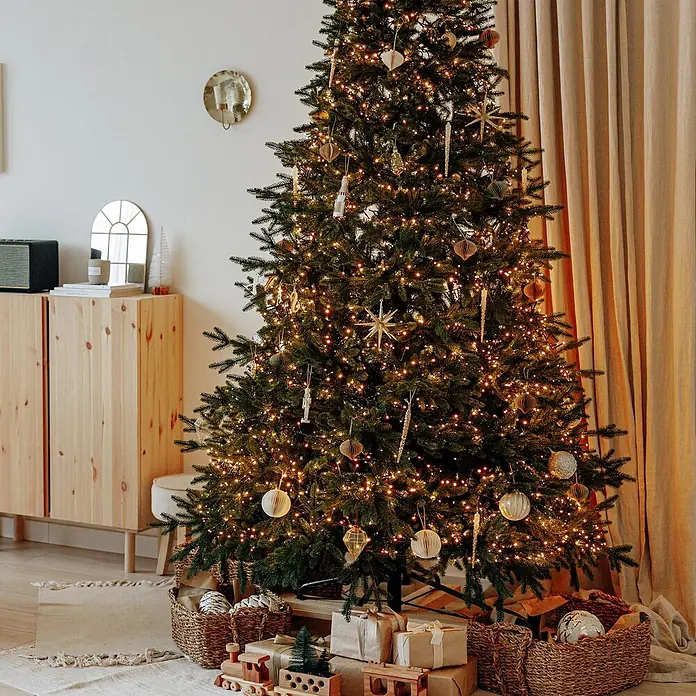 ECD Germany LED-Lichterkette 700 LEDs 14m für Innen & Außen IP44 Kaltweiß - Außen, Lichtfarbe: Warmweiß, Anzahl Leuchtmittel: 700 Stk., Netzbetrieben - Ein hell beleuchteter Weihnachtsbaum, geschmückt mit warmen Lichtern und verschiedenen gold- und neutralfarbenen Ornamenten, umgeben von Geschenken.