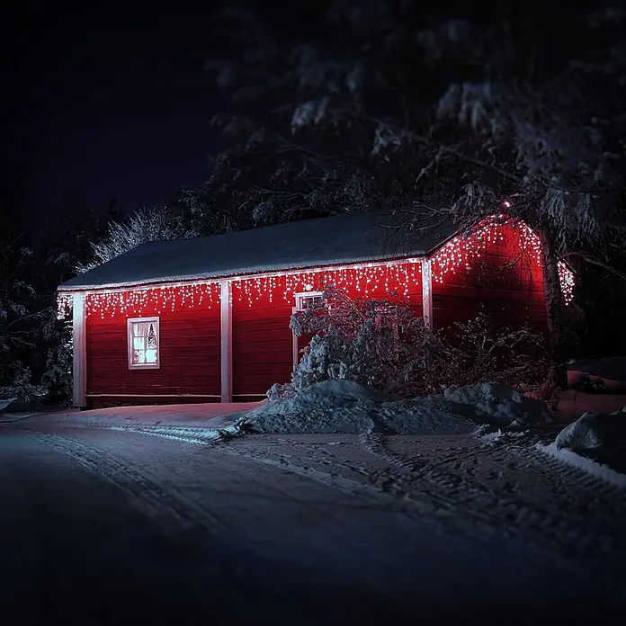 ECD Germany LED-Lichtervorhang 180 LEDs 6m für Innen & Außen IP44 Kaltweiß - Innen, 600 cm, Kaltweiß, 180 Stk., Netzbetrieben - Rotes Gebäude, geschmückt mit festlichen rot-weißen Lichtern in einer verschneiten Winternacht.