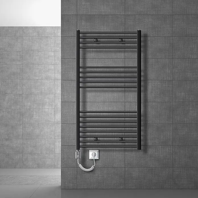 LuxeBath Elektro-Badheizkörper Designheizkörper Sahara Handtuchheizkörper Handtuchwärmer - B x H: 75 x 120 mm - Schwarzer Heizkörper-Handtuchhalter an einer grau gefliesten Wand, an eine Steckdose angeschlossen.