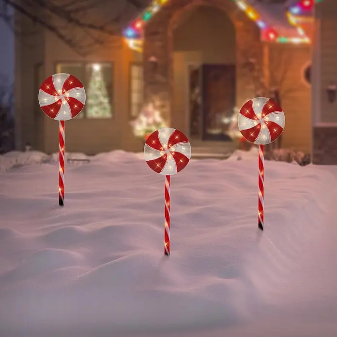 ECD Germany LED-Weihnachtsdekofigur Lollipop-Weihnachtsweg Weihnachten Lutscher Lichterkette Gartenleuchte - 300 x 18 x 62 cm, Rot, Weiß, Akkubetrieben, LED - Drei beleuchtete rot-weiße Zuckerstangen-Lutscher stehen im Schnee und schmücken ein Haus zu Weihnachten.