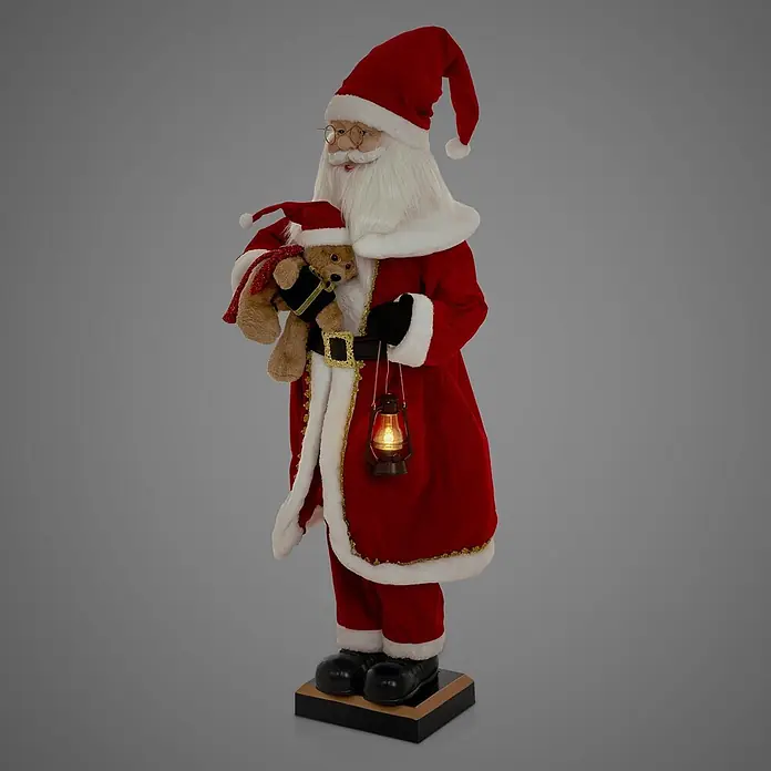 ECD Germany LED-Weihnachtsdekofigur - Rot, Weiß, Schwarz, Netzbetrieben, LED - Weihnachtsmann-Figur in rotem Anzug mit weißem Besatz, hält einen Teddybären mit roter Mütze und eine leuchtende Laterne, auf dunklem Sockel stehend.
