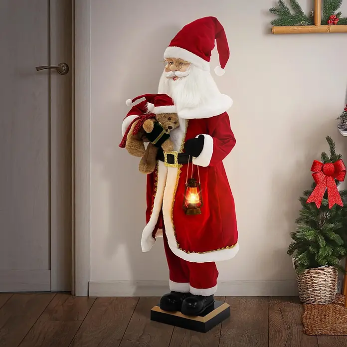 ECD Germany LED-Weihnachtsdekofigur - Rot, Weiß, Schwarz, Netzbetrieben, LED - Eine stehende, lebensgroße Weihnachtsmannfigur in rotem Anzug mit weißem Besatz, die eine leuchtende Laterne und einen Teddybär hält. Er steht auf einem Holzboden.