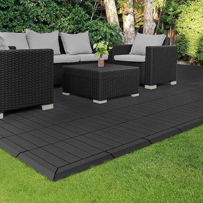 ML-Design Terrassenfliese Randabschlussleiste links Anthrazit 38x2x7,5 cm Eckleiste Umrandung - Anthrazit - Dunkelgrau/schwarze Klick-Terrassenfliesen mit angeschrägten Kanten bilden eine Terrasse mit Rattanmöbeln.