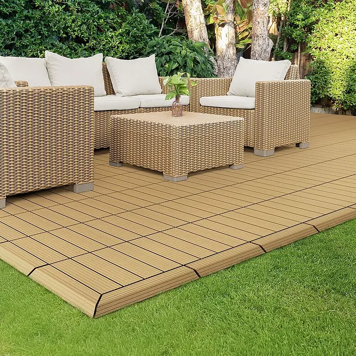 ML-Design Terrassenfliese Randabschlussleiste Ecke rechts Teak 38x2x7,5 cm Eckleiste Umrandung - Teak - Hellbraune, ineinandergreifende Terrassenfliesen bilden eine Außenterrasse, mit passenden Korbmöbeln darauf, umgeben von grünem Gras.