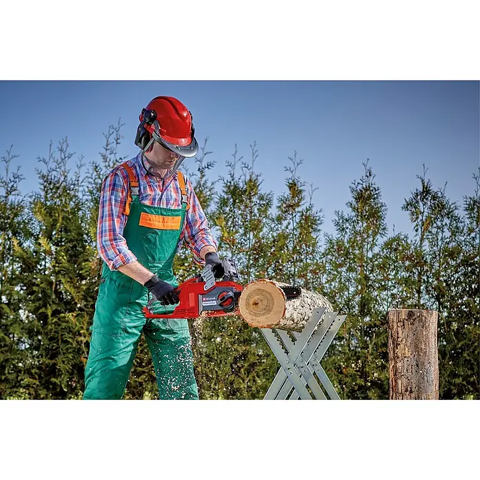 Einhell Power X-Change 18V Akku-Kettensäge FORTEXXA 18/30 - 18 V, Li-Ionen, Ohne Akku, Schwertlänge: 30 cm - Person in Schutzkleidung sägt mit roter Kettensäge einen Holzstamm auf einem Sägebock.
