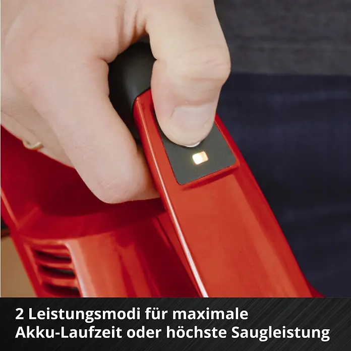 Einhell PXC 18V Akku-Staubsauger TE-SV 18 Li-Solo - 18 V, Ohne Akku, Behältervolumen: 0,6 l - Nahaufnahme einer Hand, die einen Knopf an einem roten Gerät drückt, wobei eine orangefarbene Anzeigeleuchte einen Leistungsmodus anzeigt.