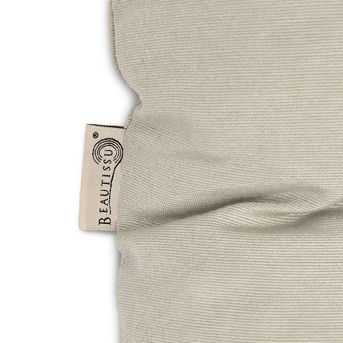 Beautissu Bankauflage Flair BK - Gartenbank, 1 Stk., Polyester, Beige - Nahaufnahme eines hellbeigen gewebten Stoffprodukts, möglicherweise ein Kissen, mit eingenähtem cremefarbenen 'BEAUTISSU' Markenetikett.