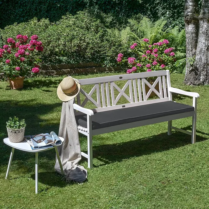 Beautissu Bankauflage Base BK - Gartenbank, 1 Stk., L x B x H: 180 x 48 x 5 cm, Polyester, Graphitgrau - Weiße Holz-Gartenbank mit dunkelgrauem Kissen, Strohhut, Decke und kleinem Beistelltisch.