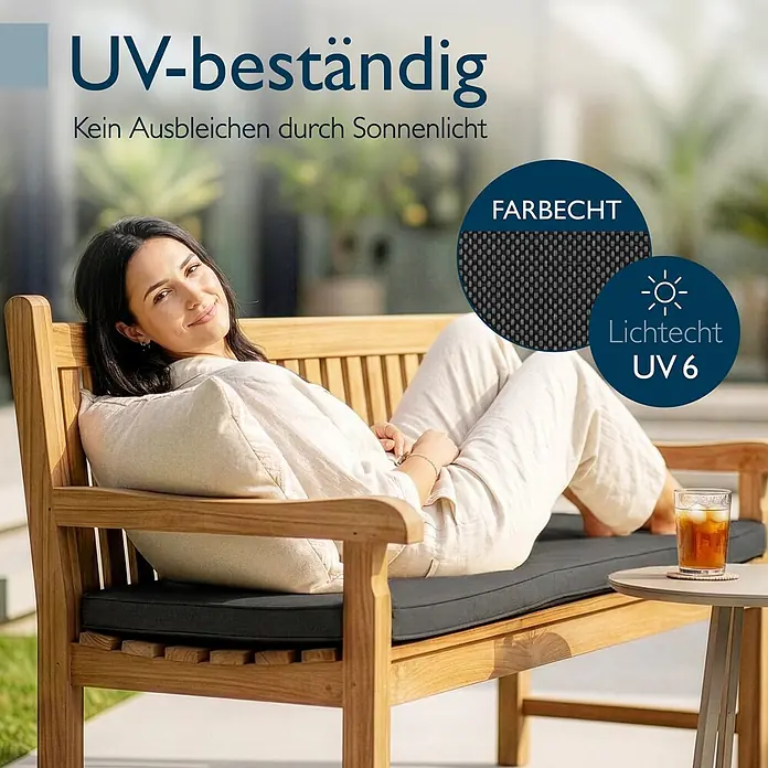 Beautissu Bankauflage QD-BK - Gartenbank, 1 Stk., L x B x H: 180 x 48 x 5 cm, Polyester, Anthrazit - Dunkelgraues, UV-beständiges Sitzkissen auf einer Holzbank, darauf entspannt eine Frau.
