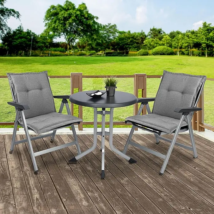 Beautissu Sitzauflage HighLux NL - Niederlehner, 6 Stk., Polyester, Hellgrau - Ein graues Outdoor-Klappmöbelset mit zwei Stühlen mit Kissen und einem runden Tisch auf einer Holzterrasse.