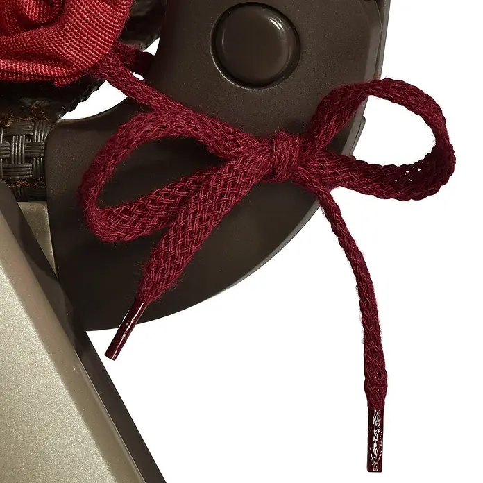 Beautissu Sitzauflage Loft NL - Niederlehner, 1 Stk., Polyester, Rot - Bordeauxroter geflochtener Schnürsenkel, zu einer Schleife auf einem dunkelbraunen Objekt gebunden, mit glänzenden Endkappen.