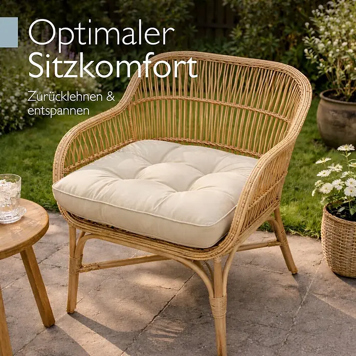 Beautissu Sitzauflage Flair LK - Outdoor Lounge, 1 Stk., L x B x H: 50 x 50 x 10 cm, Polyester, Natur - Rattansessel mit cremefarbenem Kissen in sonniger Gartenumgebung, ideal zum Entspannen.