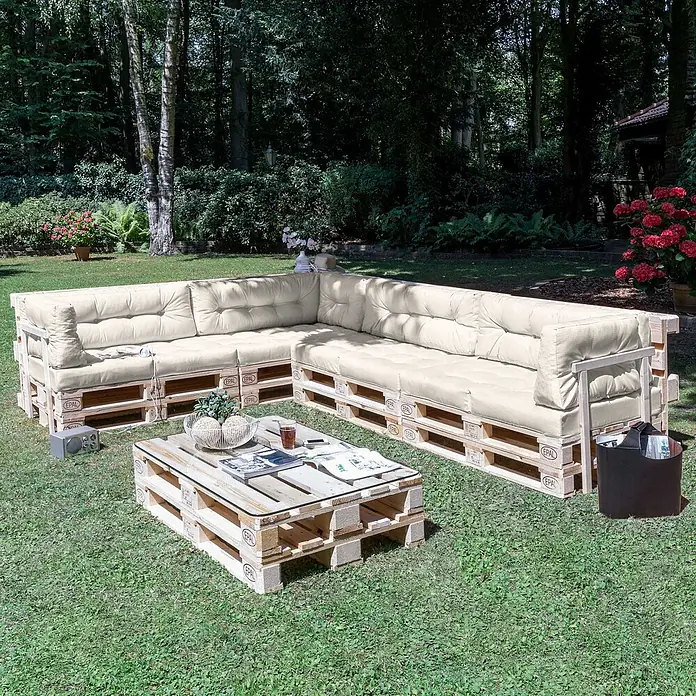 Beautissu Sitzauflage ECO Elements - Europalette, 1 Stk., Polyester, Natur - Palettenlounge-Set mit cremefarbenen Kissen und Couchtisch in Gartenumgebung.