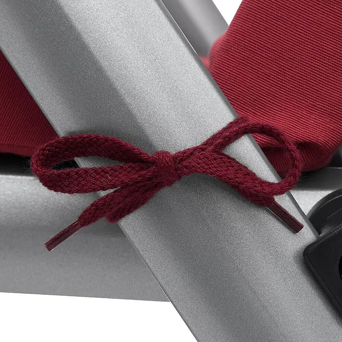 Beautissu Liegenauflage Loft RL - Rollliege, 2 Stk., Polyester, Rot - Maroon gewebter Schleifenverschluss, befestigt ein rotes Kissen an einem silbernen Rahmen.