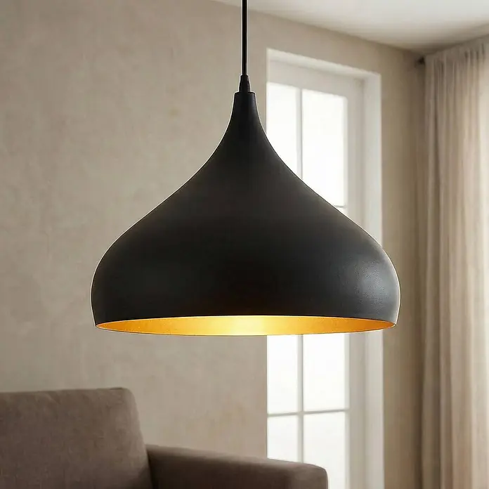 Lindby Pendelleuchte Ritana - schwarz, Schwarz, gold, E27 - Große schwarze Pendelleuchte mit warmgoldener Innenseite, die einen modernen Wohnraum beleuchtet.