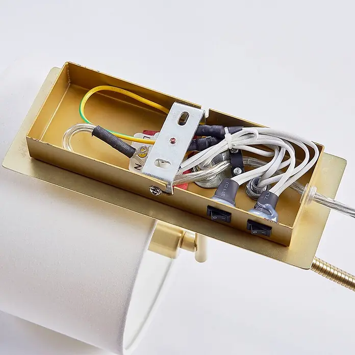 Lindby Wandleuchte Florens - messing / gold, E14 - Innenansicht einer Messing-Lampenfassung mit Verkabelung, Schaltern und Anschlüssen. Ein weißer Stoffschirm ist sichtbar.