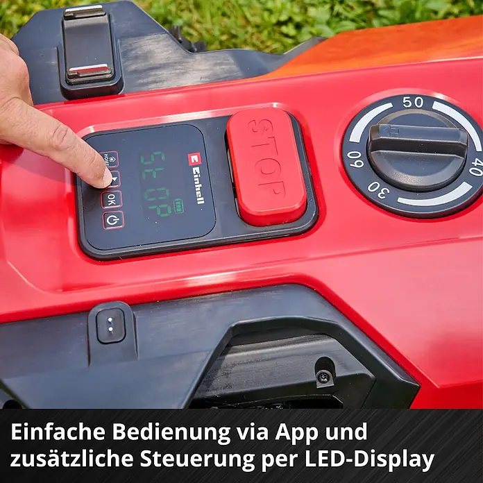 Einhell Power X-Change 18V Mähroboter Freelexo 500 - 500 m², Schnittbreite: 18 cm, Induktionsgestützte Navigation, Begrenzungskabel - Nahaufnahme des Bedienfelds eines roten Rasenroboters mit LED-Display, rotem STOP-Knopf und Drehregler. Eine Hand drückt eine Taste am Display.