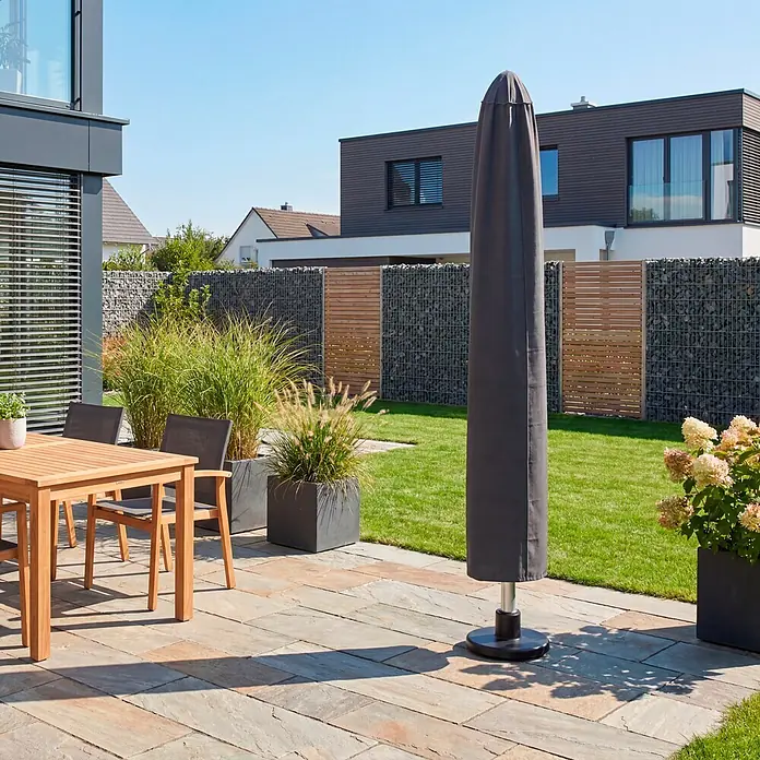 SENSUM Schirm-Schutzhülle - Kunststoff, Passend für: Schirme bis Ø 400 cm - Moderne Terrasse mit hölzerner Essgruppe, Sonnenschirm und Pflanzgefäßen auf hellen Steinplatten.