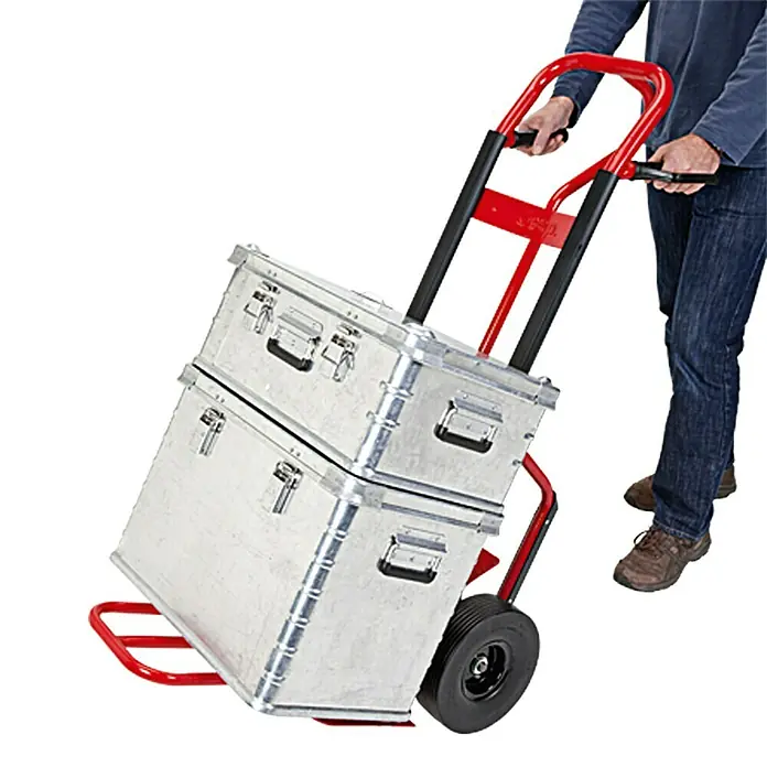 BAUHAUS Sackkarre HT 800 FRG - Stahl, Traglast: 250 kg - Eine rote Sackkarre mit zwei silbernen Metallkisten wird von einer Person transportiert. Ideal für den Transport schwerer Lasten.