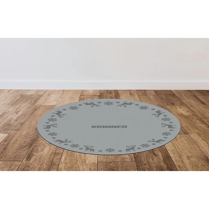 Krinner Dekoartikel - L x B x H: 60 x 60 x 0,7 cm, Grau - Rund graue Fußmatte mit festlichem Rentier- und Schneeflocken-Design, mit KRINNER-Logo, auf einem Holzboden.