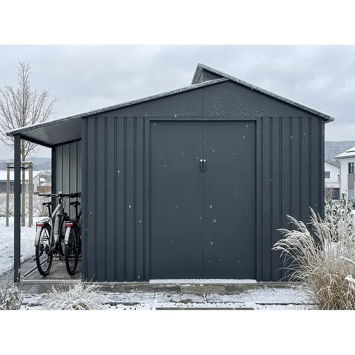 StarLine Metall Gerätehaus Viva Varianta 9,12 m² - Außenbreite inkl. Dachüberstand: 355 cm, Außentiefe inkl. Dachüberstand: 257 cm, Metall, Anthrazit - Dunkelgraues Metall-Gartenhaus mit integriertem Carport, leicht schneebedeckt, zwei Fahrräder untergestellt.
