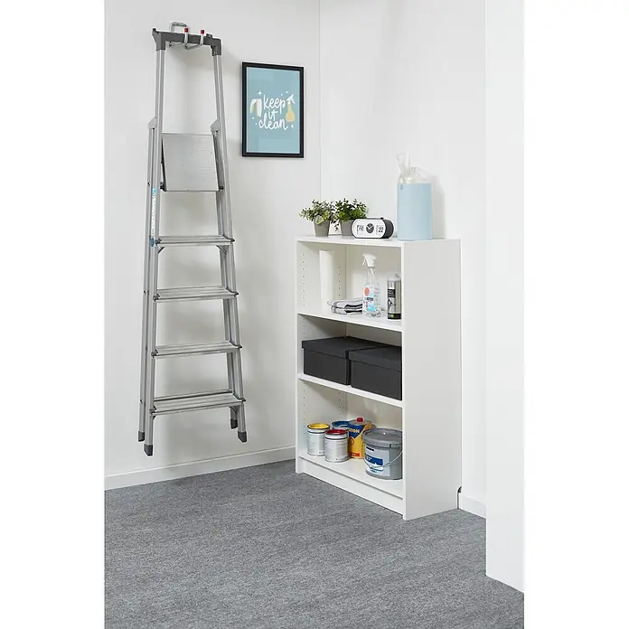 Teppichfliese Filzfliese - 40 x 40 cm, Grau, Selbstklebend, 100 % Polypropylen - Silberne Klappleiter hängt an der Wand neben einem weißen Lagerregal mit Reinigungsutensilien und Farbdosen.