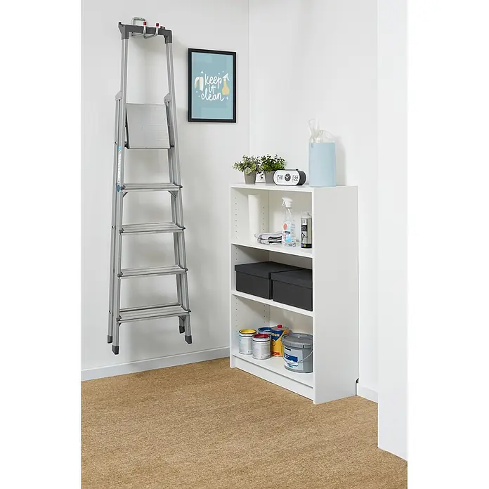 Teppichfliese Filzfliese - 40 x 40 cm, Beige, Selbstklebend, 100 % Polypropylen - Eine silberne Trittleiter hängt an einer Wand neben einem weißen Lagerregal in einem Hauswirtschaftsraum. Reinigungsmittel, Pflanzen und Farbe sind ordentlich verstaut.