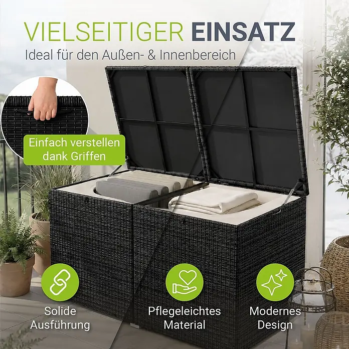 Juskys Garten-Aufbewahrungsbox Ikaria - Schwarz, Kunststoff - Schwarze Outdoor-Aufbewahrungsbox in Rattan-Optik auf einem Balkon, mit geöffnetem Deckel und Kissen/Decken darin. Seitliche Griffe sind sichtbar.