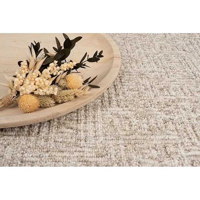 Bricoflor Teppichboden Meterware 5x5m, Schlinge gemustert, beige weiß - Schlinge, 100 % Polypropylen (PP), beige weiß - Heller, beigefarbener Teppich mit subtilem Webmuster und Trockenblumenarrangement auf Holztablett.