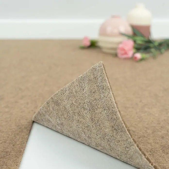 Bricoflor Teppichfliese Nadelvlies Nadelfilz, Beige Hell-Braun, 40x40cm -  - Beiges Filzteppichunterlage, eine Ecke angehoben, um ihre Faserstruktur zu zeigen. Verschwommener dekorativer Hintergrund.