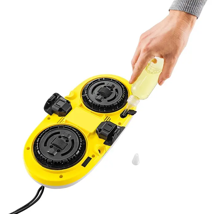 Kärcher Fensterreinigungsroboter RCW 2 - Wassertankvolumen Roboter: 70 ml, Saugkraft: 3.300 Pa - Gelb-schwarzes Reinigungsgerät wird von einer Hand aus einer Flasche mit gelber Reinigungslösung nachgefüllt.