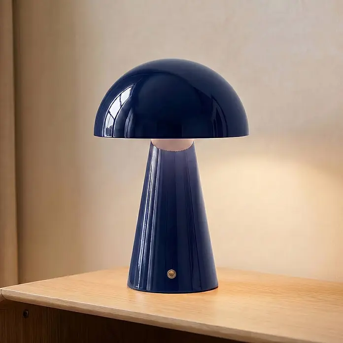Lindby Tischleuchte Nevijo - blau, blau - Eine glänzende, marineblaue Pilztischlampe mit geriffelter konischer Basis, beleuchtet auf einer Holzoberfläche.