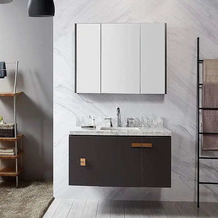 Hudor Badmöbel-Set -  - Ein modernes, schwebendes dunkelgraues Badezimmermöbel mit Marmorplatte und goldenen Griffen, darüber ein Spiegelschrank mit drei Türen.