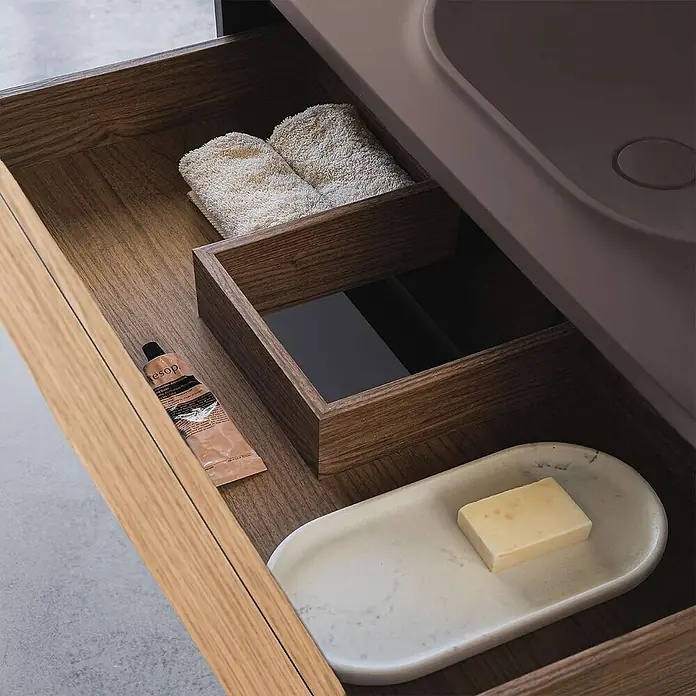 Poalgi Badmöbel-Set BÜL - Gesamtbreite Badmöbel: 80 cm, Eiche und Braun, Matt - Geöffnete dunkelbraune Waschtischschublade aus Holz mit integriertem braunen Waschbecken, enthält Handtücher, Seife auf Marmor und Kosmetik.