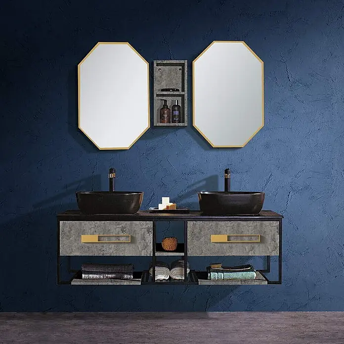 Hudor Badmöbel-Set cw20016 -  - Doppel-Badezimmermöbel mit zwei achteckigen, goldgerahmten Spiegeln, schwarzen Aufsatzwaschbecken und einer Betonoptik-Kommode mit goldenen Griffen an einer dunkelblauen Wand.