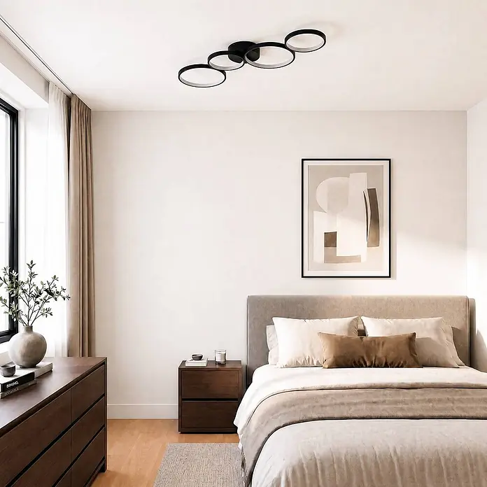 Lindby Deckenleuchte Evengeline - schwarz - Eine moderne schwarze Deckenleuchte mit fünf verbundenen Ringen, in einem Schlafzimmer installiert.